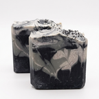 Two black and white marbled soap bars on a white background
