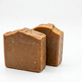 Two pieces of pine tar soap on a white background