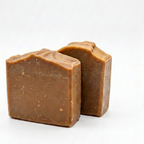Two pieces of pine tar soap on a white background